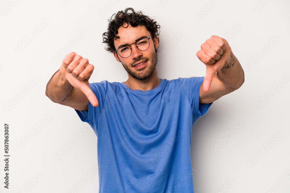 Young caucasian man isolated on white background showing thumb down and expressing dislike. Young caucasian man isolated on white background showing thumb down and expressing dislike.
