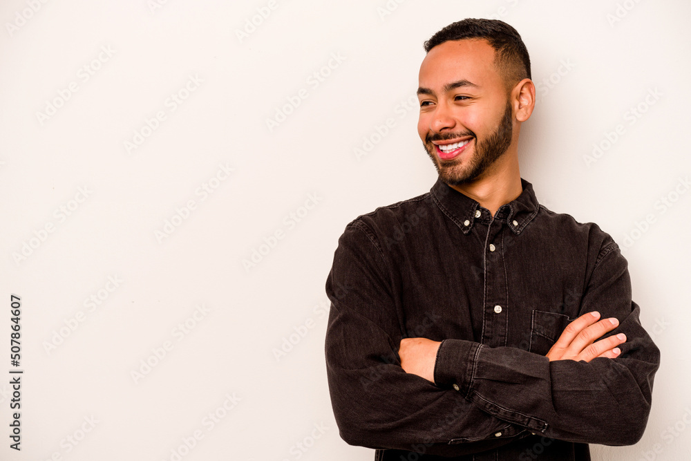 Fototapeta premium Young hispanic man isolated on white background smiling confident with crossed arms.