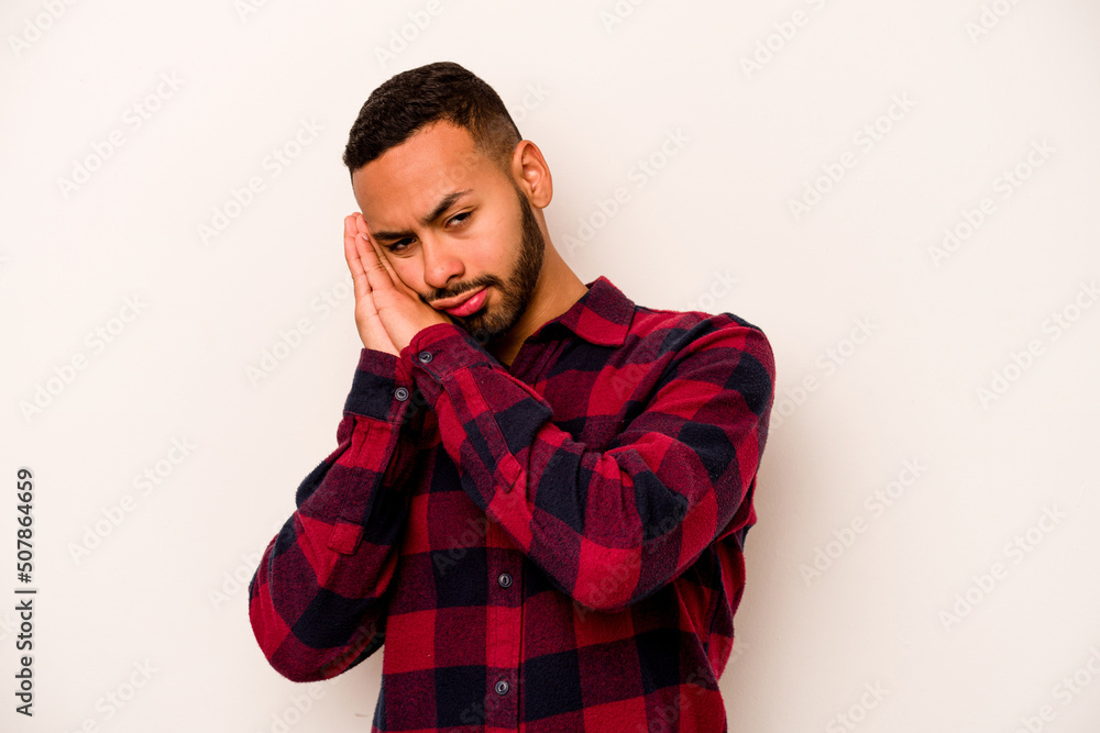Young hispanic man isolated on white background yawning showing a tired gesture covering mouth with hand. Young hispanic man isolated on white background yawning showing a tired gesture covering mouth with hand.