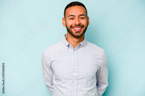 Young hispanic man isolated on blue background happy, smiling and cheerful. © Asier