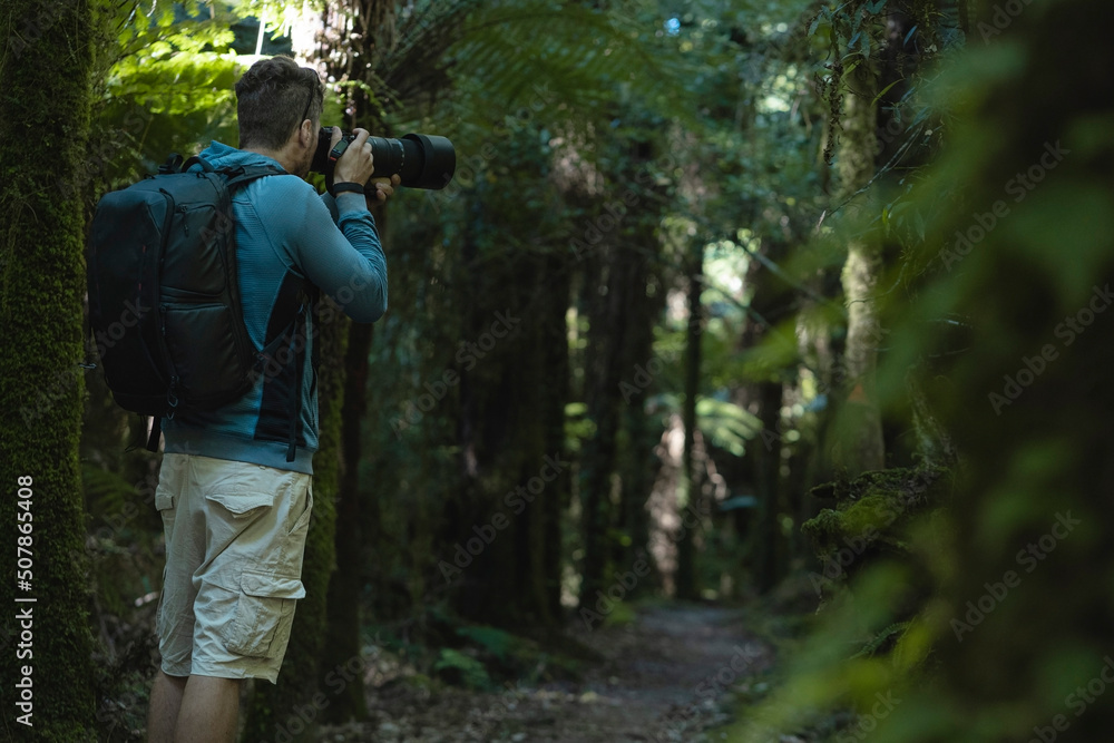 Man taking photos in the wilderness of a big forest Man taking photos in the wilderness of a big forest