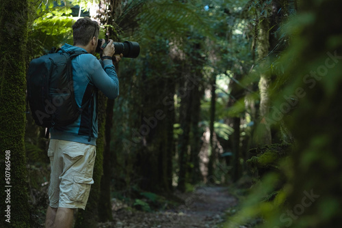 Man taking photos in the wilderness of a big forest © Pajaros Volando