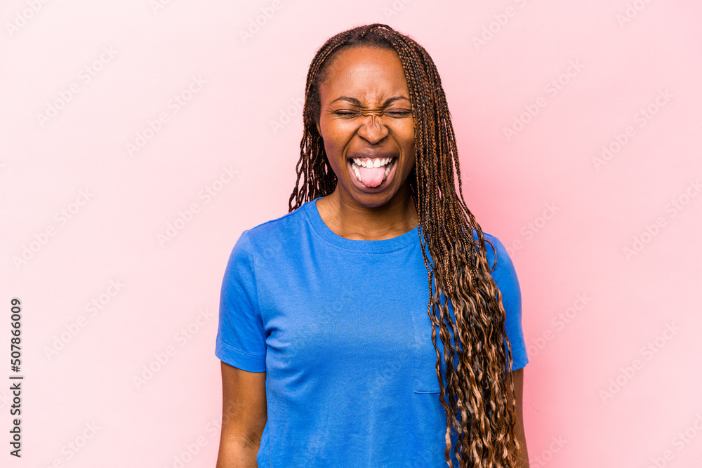 Young african american woman isolated on pink background funny and friendly sticking out tongue. Young african american woman isolated on pink background funny and friendly sticking out tongue.
