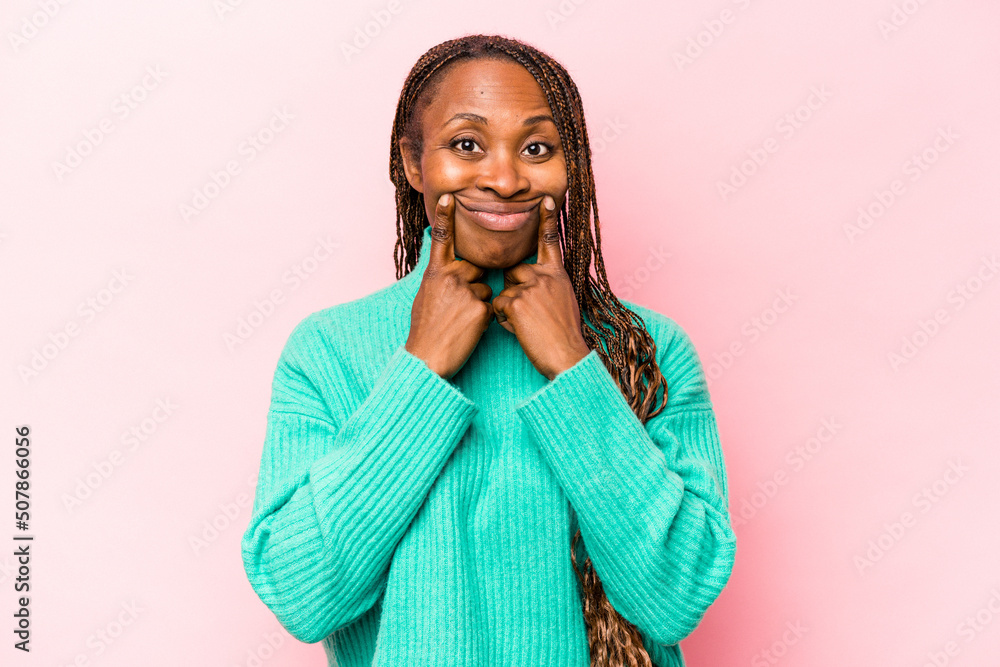 Young african american woman isolated on pink background doubting between two options. Young african american woman isolated on pink background doubting between two options.