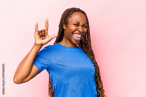 Fotografie, Obraz Young african american woman isolated on pink background showing a horns gesture as a revolution concept