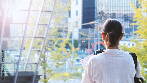 Canvas Print Behind tourist or traveller standing taking a photo of tower in Osaka Japan near station around Umeda area by dslr camera in hands and have a sunset flare in the evening day