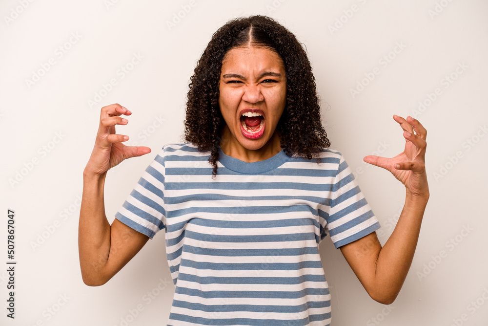 Young African American woman isolated on white background screaming with rage. Young African American woman isolated on white background screaming with rage.