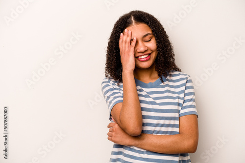 Young African American woman isolated on white background laughing happy, carefree, natural emotion. © Asier