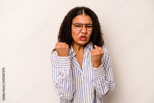 Young African American woman isolated on white background showing fist to camera, aggressive facial expression. © Asier