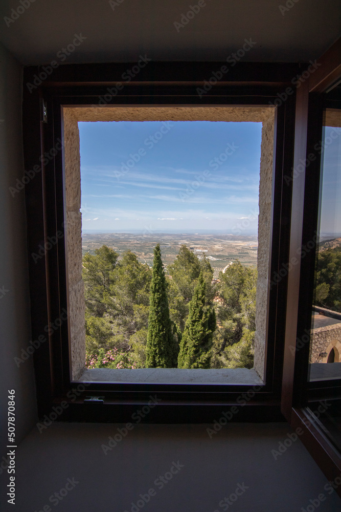 A wooden window seen from inside a room at the Parador de Jaen hotel. Beautiful views of the city of Jaen, Spain. A wooden window seen from inside a room at the Parador de Jaen hotel. Beautiful views of the city of Jaen, Spain.