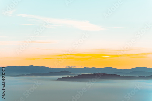 view of sunrise above mountains mist in the bottom © phpetrunina14