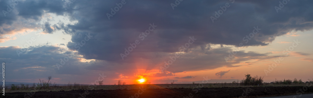 Panorama nature sunset. Beautiful evening sky. The sun sets over the horizon Panorama nature sunset. Beautiful evening sky. The sun sets over the horizon