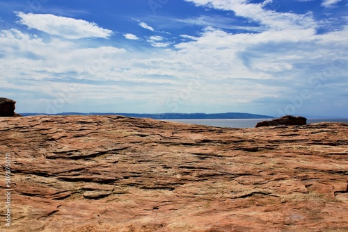Red rocks and sky overlooking coast.