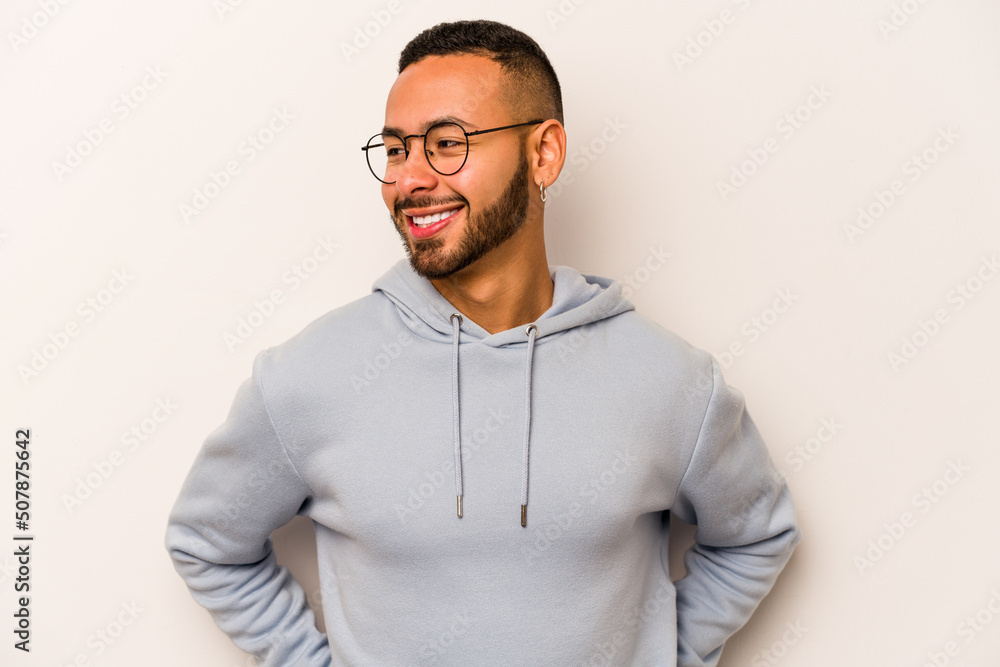 Young hispanic man isolated on white background laughs happily and has fun keeping hands on stomach. Young hispanic man isolated on white background laughs happily and has fun keeping hands on stomach.