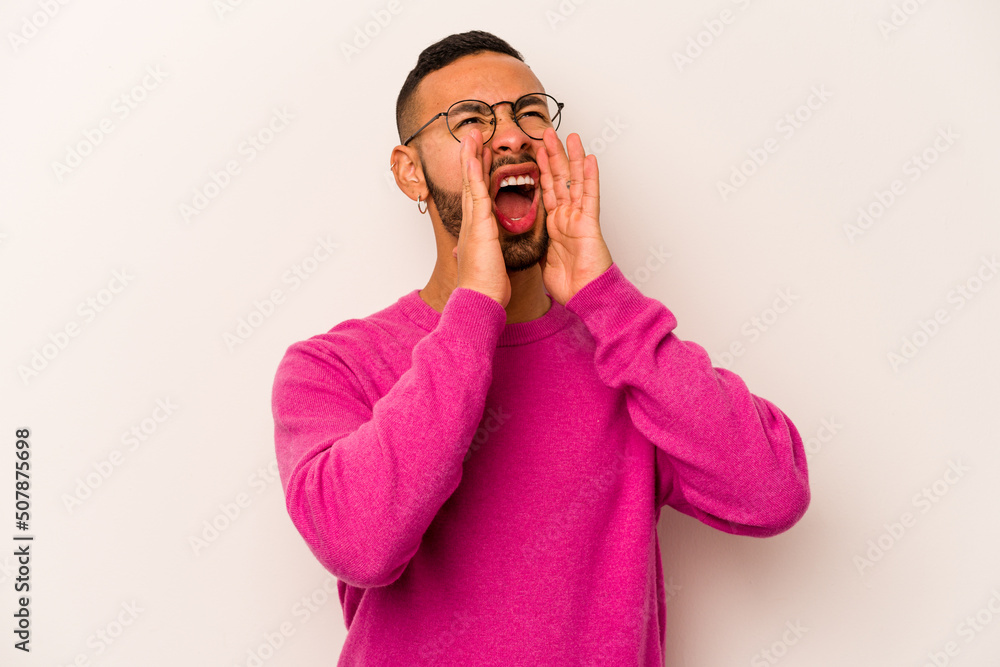 Young hispanic man isolated on white background shouting excited to front. Young hispanic man isolated on white background shouting excited to front.