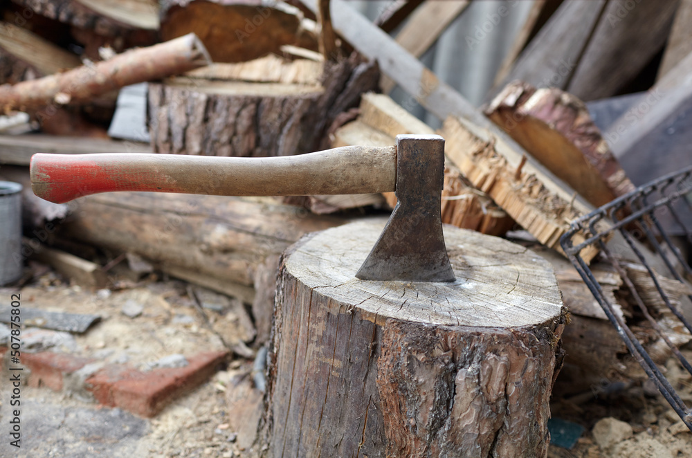 Ax in the stump. Axe for cutting wood. Preparation of firewood for the winter. Selective focus, blurred background Ax in the stump. Axe for cutting wood. Preparation of firewood for the winter. Selective focus, blurred background
