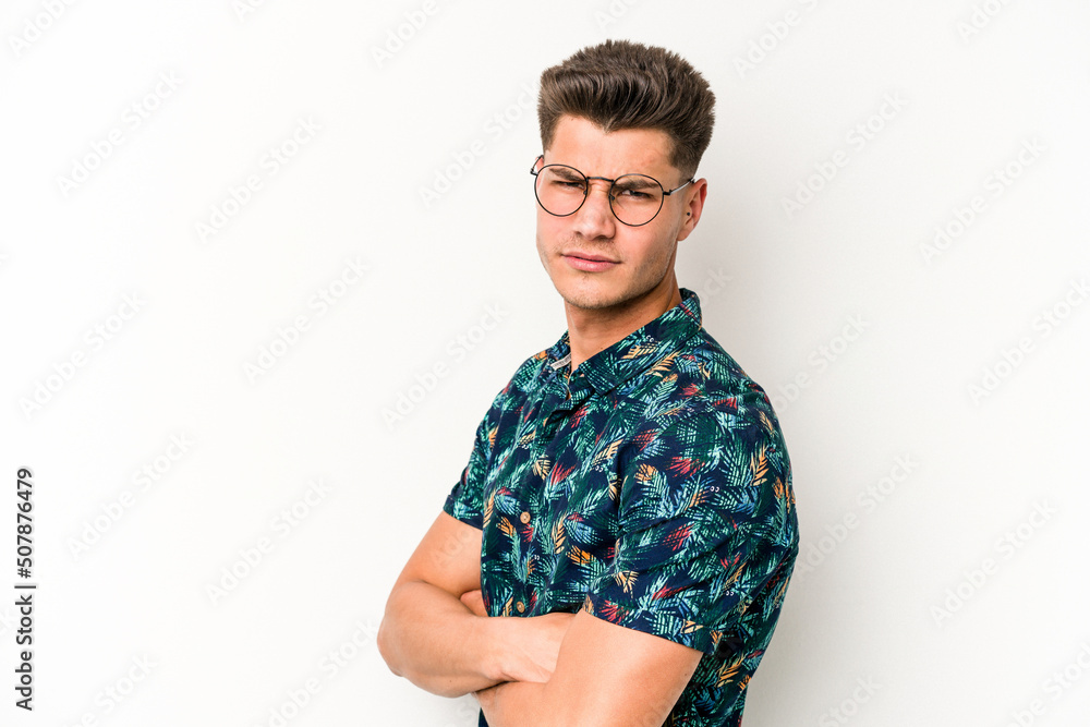 Young caucasian man isolated on white background suspicious, uncertain, examining you. Young caucasian man isolated on white background suspicious, uncertain, examining you.