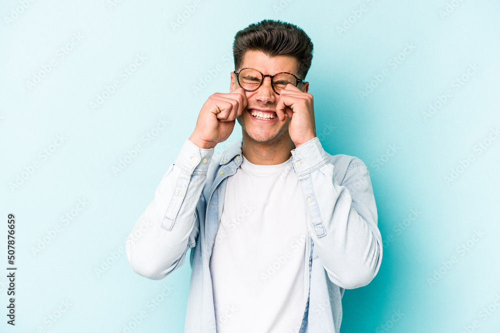 Young caucasian man isolated on blue background whining and crying disconsolately. Young caucasian man isolated on blue background whining and crying disconsolately.