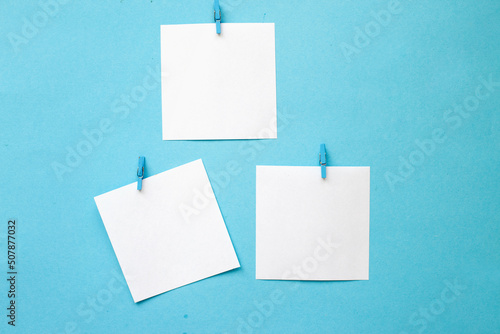 white stickers with empty mockup hanging on pin on blue background. Copy space for your text