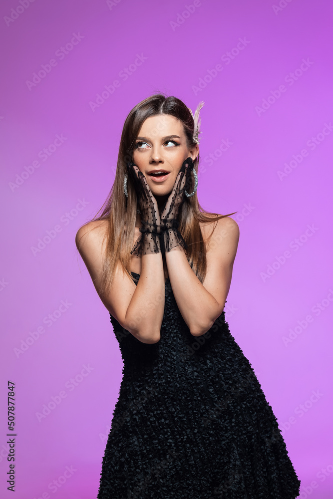 Stunning brunette in a black dress poses, vivid emotions actress. Portrait of a Girl. Colorful background Stunning brunette in a black dress poses, vivid emotions actress. Portrait of a Girl. Colorful background