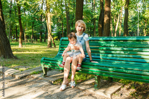 beautiful girl with children sits on a bench in the park © Minakryn Ruslan 