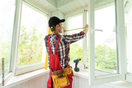 Fotografie, Tablou Man measuring window prior to installation of roller shutter outdoors