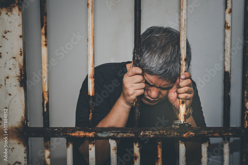 Slika na platnu Asian male criminals was arrested and handcuffed  in a dirty cage, concept to th