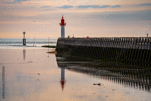 Lighthouse at the entrance to the harbor on the coast of Normandy in France. photo