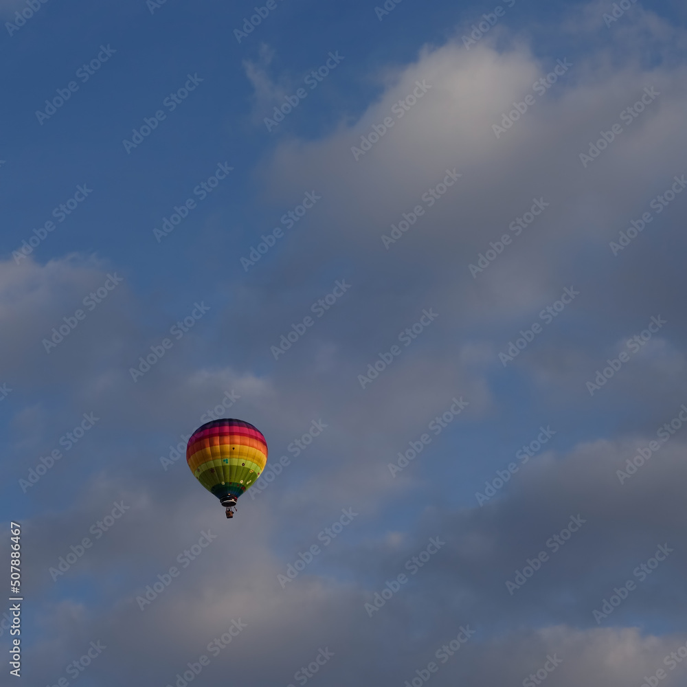 Montgolfière multicolore dans un ciel nuageux Montgolfière multicolore dans un ciel nuageux
