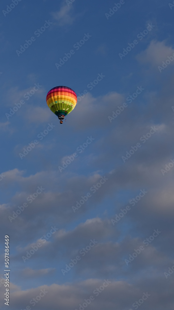 Fototapeta premium Montgolfière multicolore dans un ciel nuageux