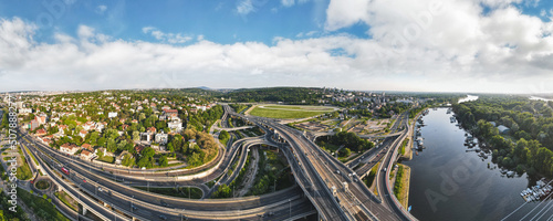Aerial skyline cityscape view of Belgrade, Serbia, in the morning. Aerial drone view of Ada Ciganlija lake, hippodrome and traffic driving over intersection in Belgrade. Urban scene