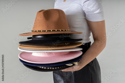 Valokuva Fashionable woman with many hats, posing on gray background