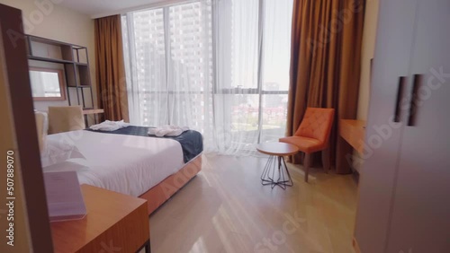 BATUMI, GEORGIA - MAY 22, 2022: Interior of hotel has large bed and floor-to-ceiling windows. Flight of camra across room. Concept of hotel business or investment in real estate. Real estate services. photo