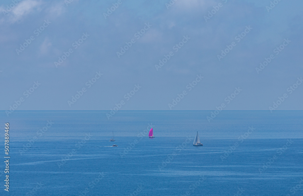 A beautiful summer scene with boats sailing on the high seas.