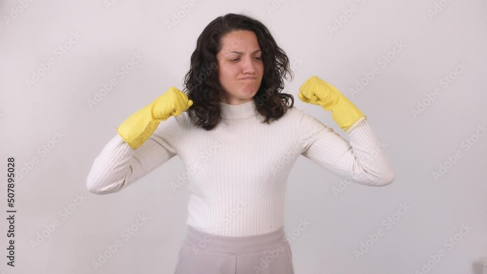 A young housewife in yellow rubber gloves rubs her hands together and dances happily for the camera A young housewife in yellow rubber gloves rubs her hands together and dances happily for the camera