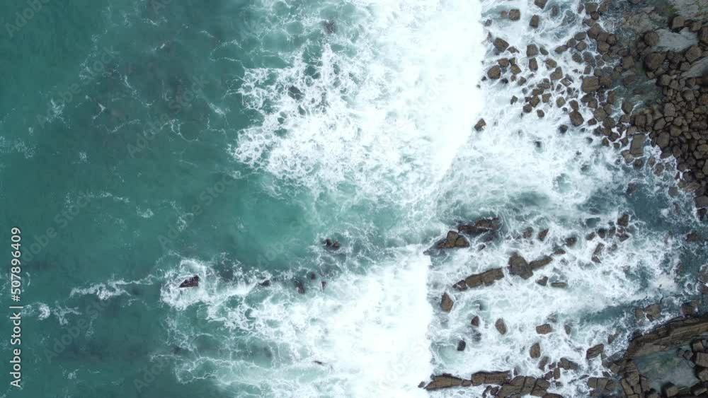 WAVES BREAKING ON ROCKS IN THE SEA OF THE COAST OF THE BASQUE COUNTRY FROM DRONE IN AERIAL VIEW WAVES BREAKING ON ROCKS IN THE SEA OF THE COAST OF THE BASQUE COUNTRY FROM DRONE IN AERIAL VIEW