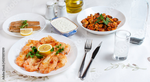 Grilled prawns or shrimps with lemon, top view. Traditional Greek tavern menu. Variety of seafood dinner.