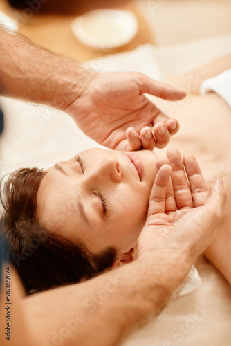 Wallpaper Mural Warm toned portrait of beautiful young woman enjoying face massage in SPA center with eyes closed Torontodigital.ca