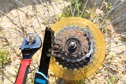 Old bicycle's rusty gears next to repair tools