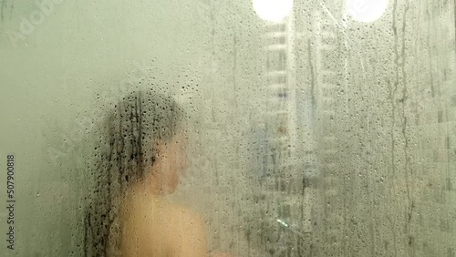 woman taking shower view through misty glass