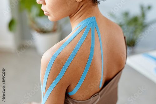 Close up of young black woman with physio tape on shoulder in rehabilitation therapy, copy space