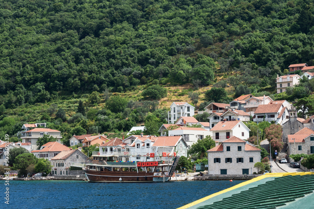 Ferry crossing Kamenari-Lepetani Montenegro in the Bay of Kotor. View of the mountains, houses from the ferry. Travel Montenegro.