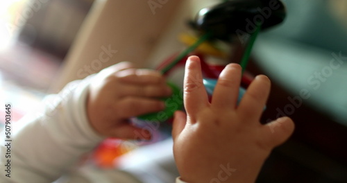 Baby hands holding play toy, close-up infant plays with child development toys