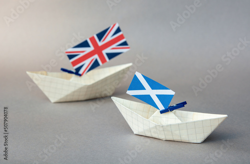 paper ships with the scotland and the UK flag -  relations   in the kingdom, independence and a referendum concept photo