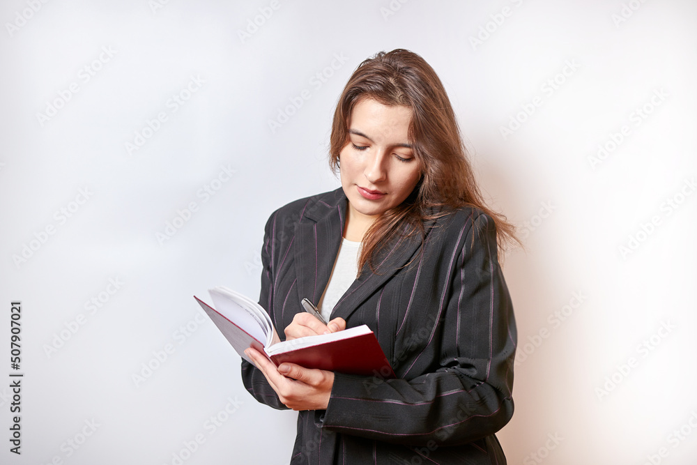 Beautiful businesswoman makes a note in a notebook. Beautiful businesswoman makes a note in a notebook.