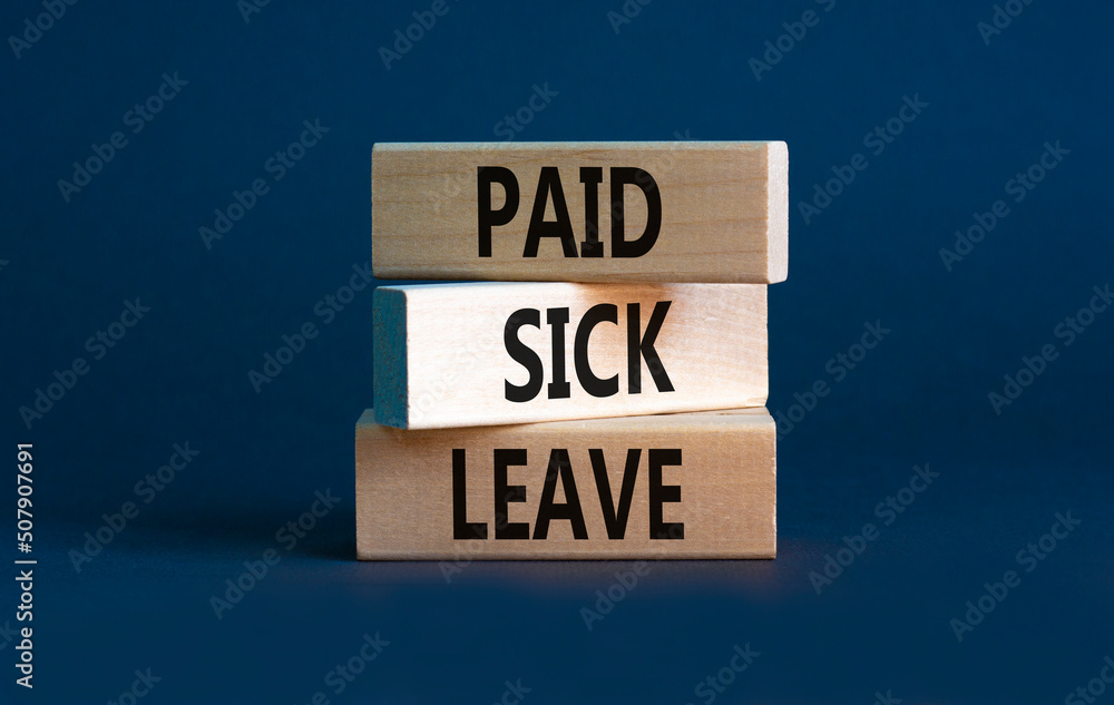 Paid sick leave symbol. Concept words Paid sick leave on wooden blocks. Beautiful grey table grey background. Business medical and paid sick leave concept. Copy space.