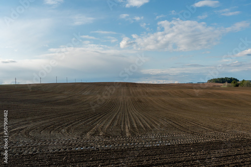 Rows of soil before planting. Drawing of furrows on a plowed field prepared for spring sowing of agricultural crops. View of the land prepared for planting and growing crops.