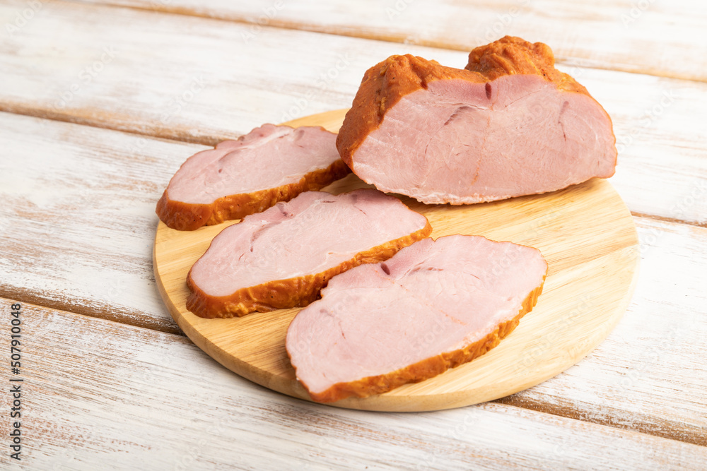 Smoked pork ham on white wooden background. Side view, close up.