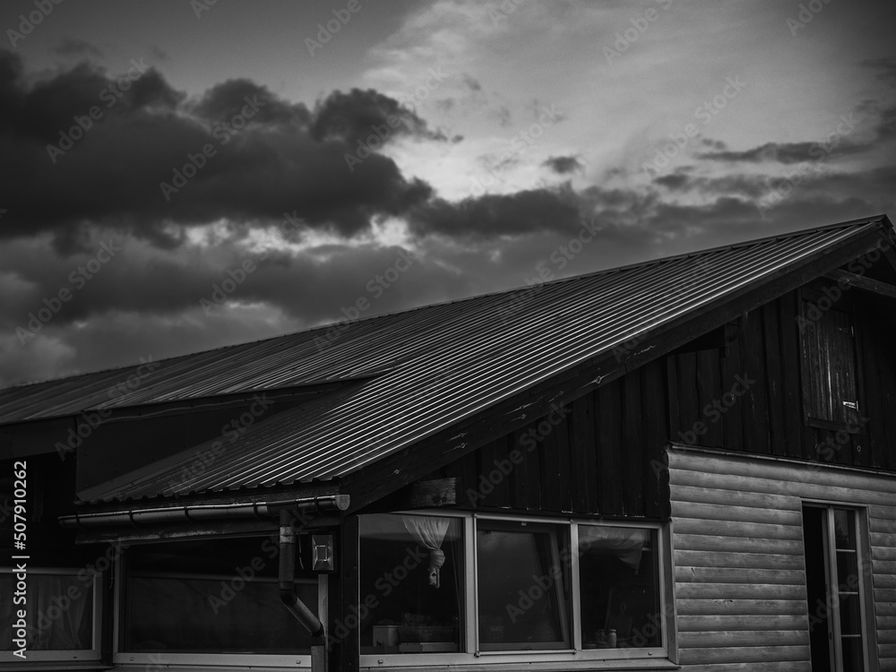 Part of the house and the roof in cloudy weather. black and white