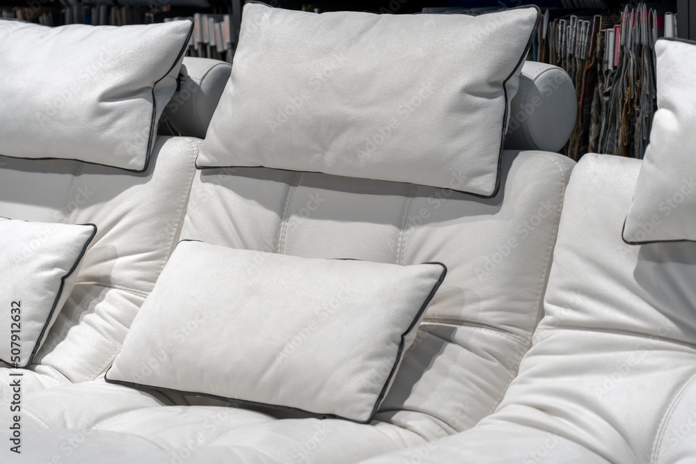 Fototapeta premium Empty cozy white leather sofa with pillows at hotel